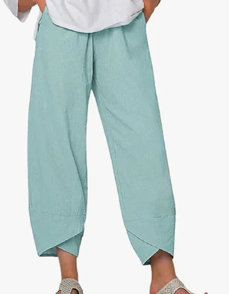 Light blue cropped pants with unique layered hems worn with white top and beige woven sandals