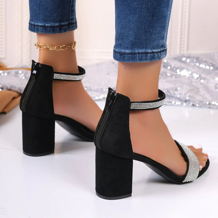 Black block heel sandals with rhinestone straps, modeled with blue jeans and gold anklet