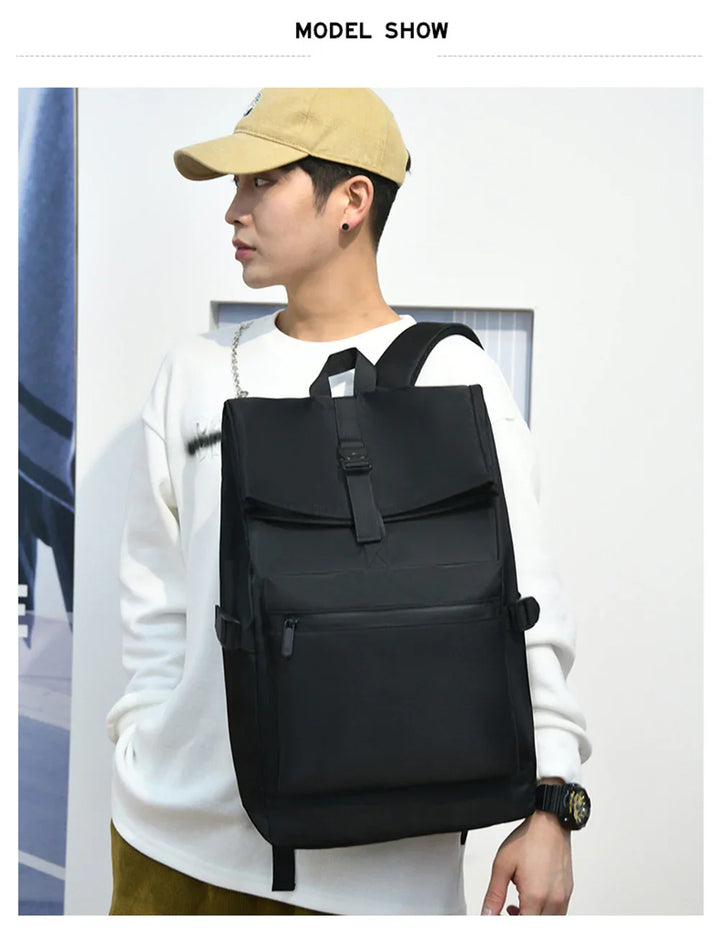 Young man wearing beige cap and white sweatshirt carrying large black backpack with front pocket