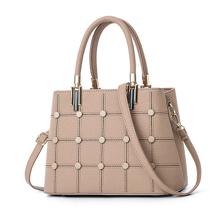 Beige leather handbag with grid pattern and round studs, double handles, and detachable shoulder strap