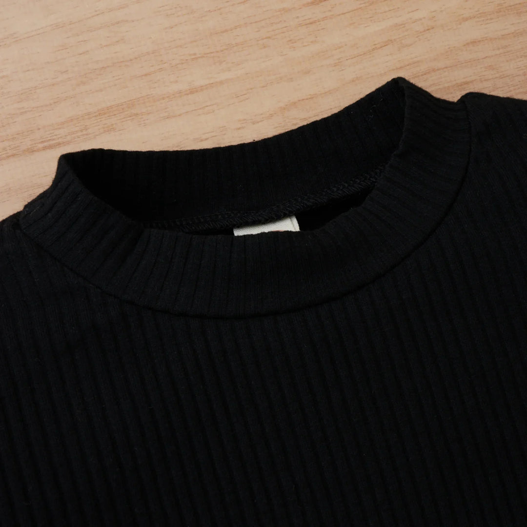 Close-up of black ribbed knit sweater neckline on wooden surface
