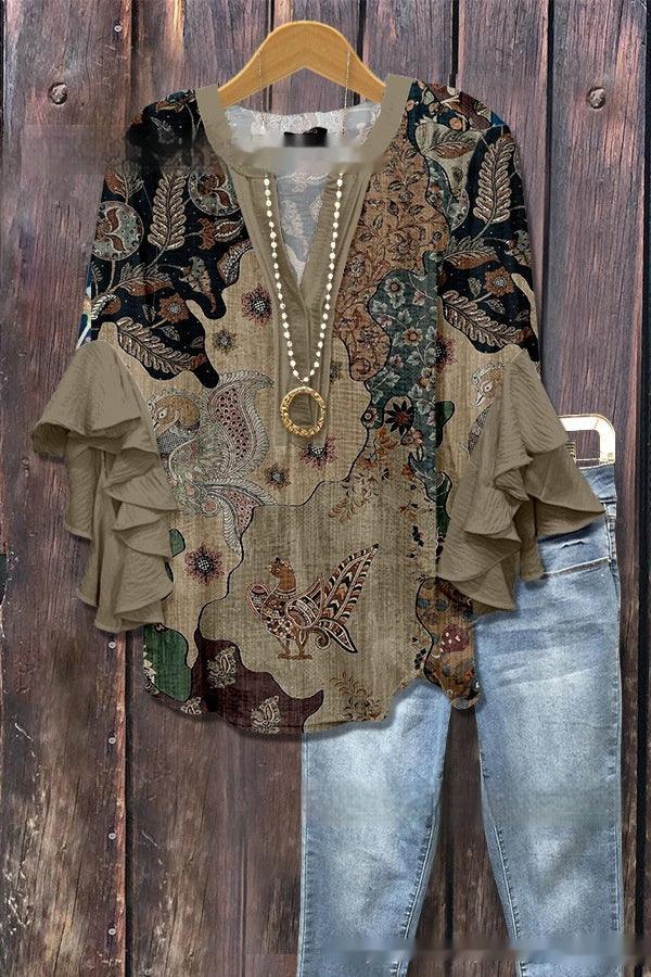 Boho style floral printed blouse with tiered ruffle sleeves and layered necklace, paired with light blue denim jeans on wooden background