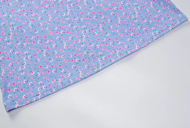 Blue fabric with small pink and white floral print pattern on light background