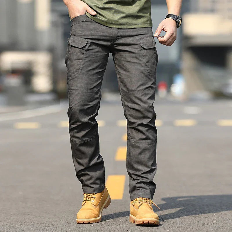 Man wearing dark gray cargo pants and tan work boots standing on a street