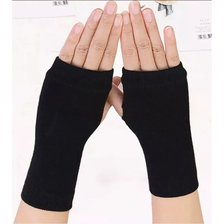 Hands wearing black fingerless gloves on white surface with papers