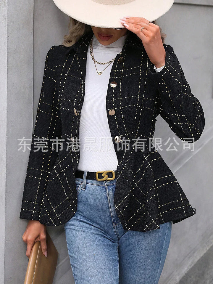 Woman wearing black plaid blazer, white turtleneck, blue jeans, beige hat, and gold jewelry