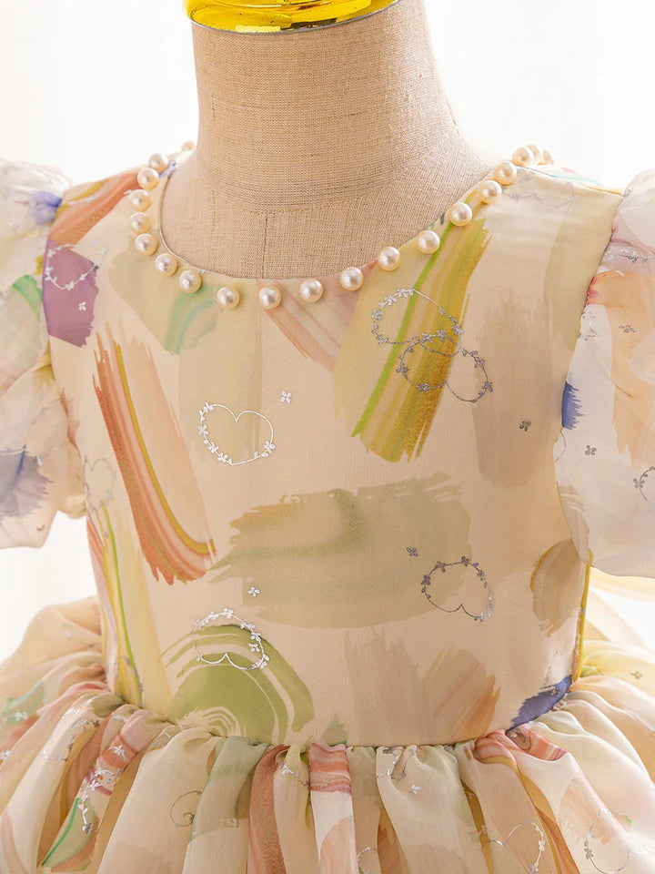 Close-up of pastel watercolor print dress with puff sleeves and pearl neckline on mannequin