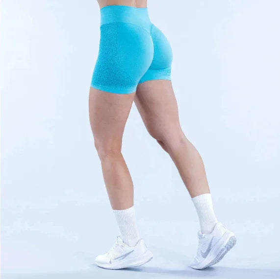 Woman wearing aqua blue seamless workout shorts, white socks, and white sneakers
