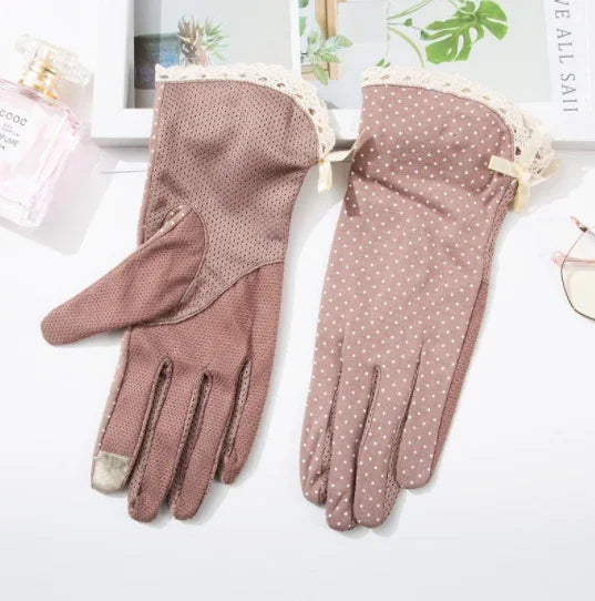 Pair of brown cotton gloves with lace trim and polka dot pattern on a white surface