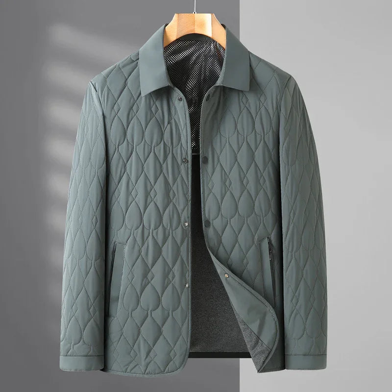 Gray quilted jacket with diamond and teardrop stitching, snap buttons, and collar on wooden hanger