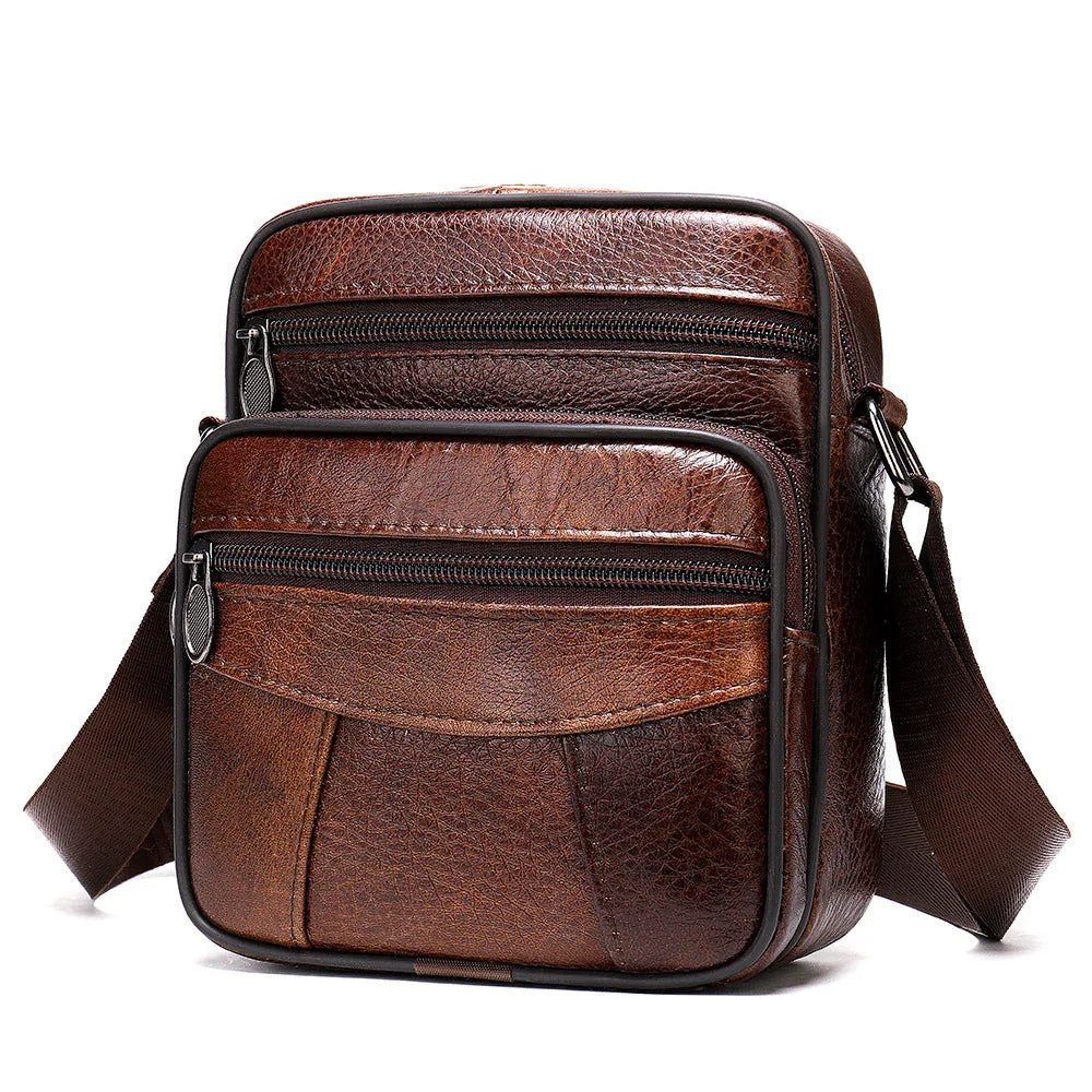 Brown leather crossbody bag with front zippered pockets and adjustable strap on white background