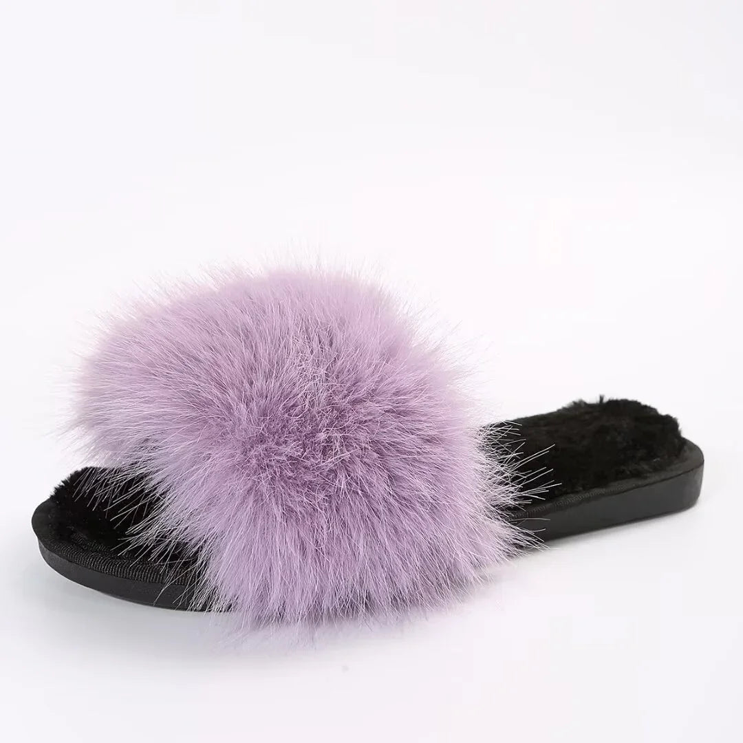 Black slipper with soft purple fluffy fur strap and black furry sole on white background