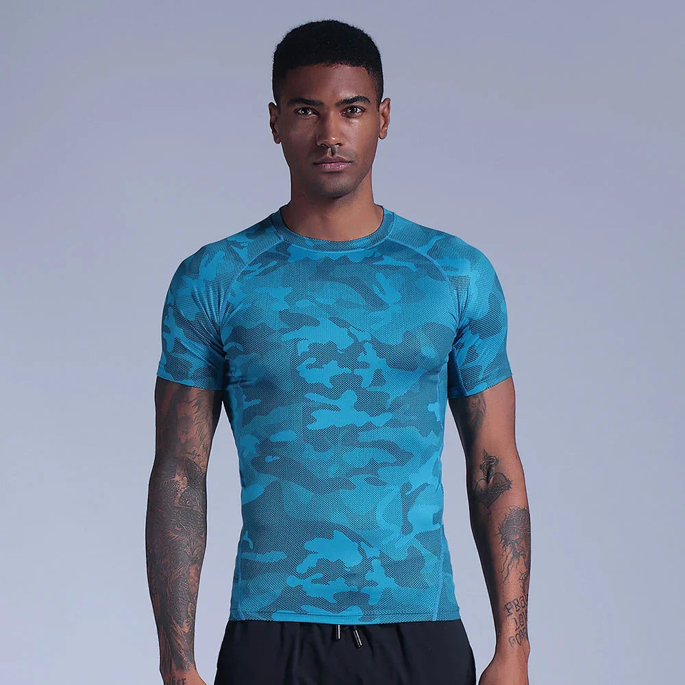 Man wearing blue camouflage fitted athletic t-shirt with tattooed arms on gray background