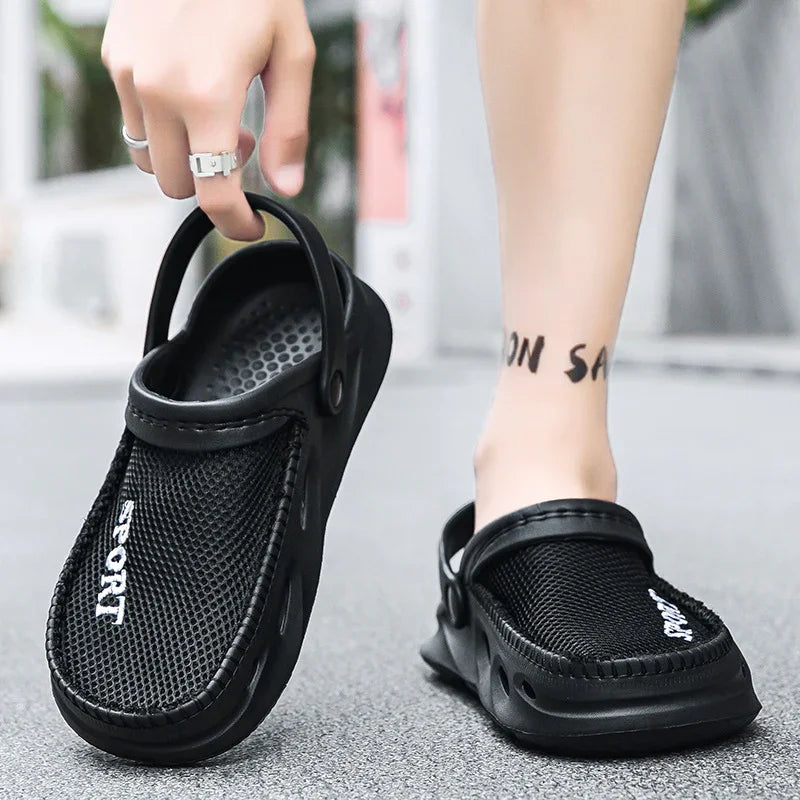 Black breathable mesh sport clogs with adjustable heel strap worn on foot and held by hand
