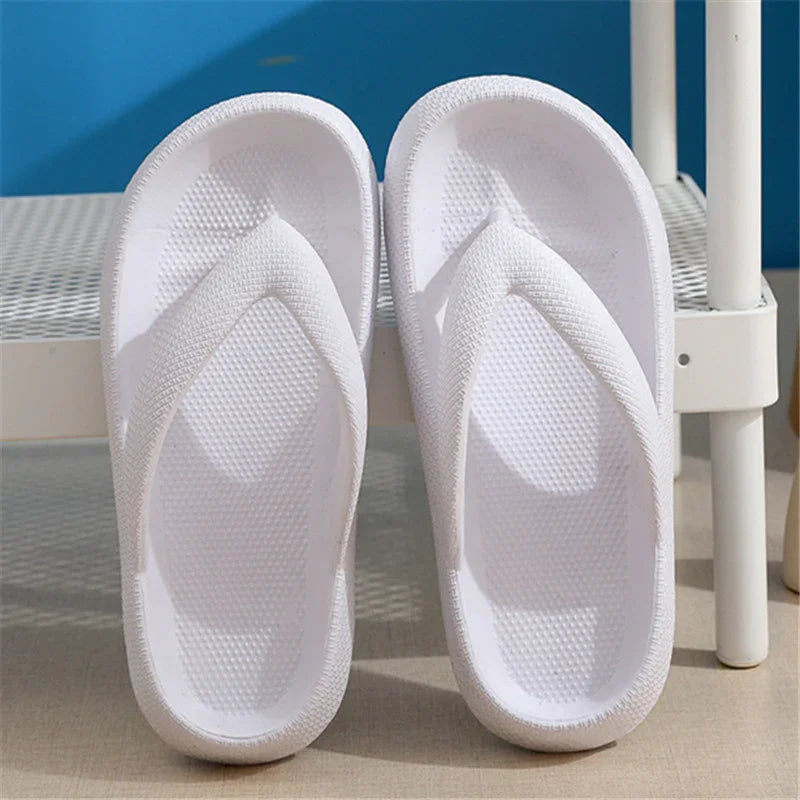 Pair of white textured flip-flops on floor next to white metal chair with blue background