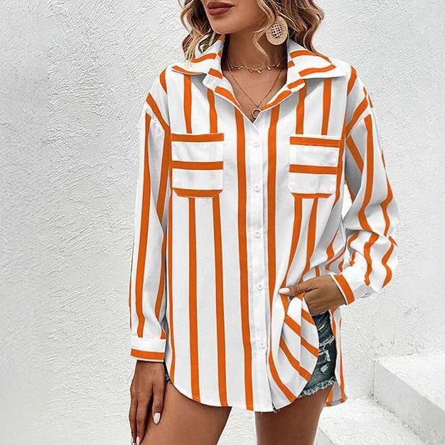 Woman wearing long-sleeve white shirt with vertical orange stripes and front pockets, paired with denim shorts