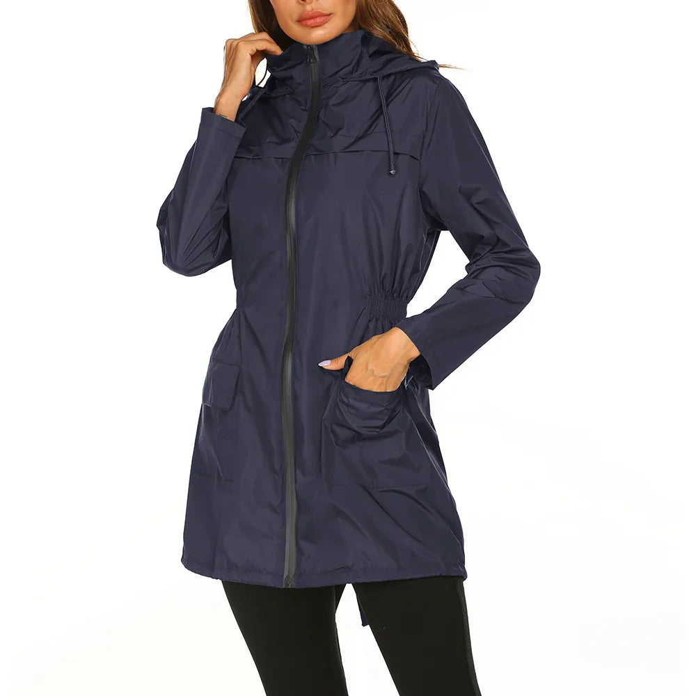 Woman wearing navy blue lightweight raincoat with hood, front zipper, and pockets