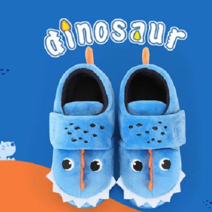 Blue plush toddler slippers with dinosaur face design and eyes on bright blue background