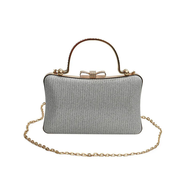 Silver glitter evening clutch handbag with gold chain strap and bow clasp