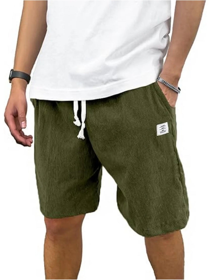 Man wearing olive green textured shorts with white drawstring and a white t-shirt