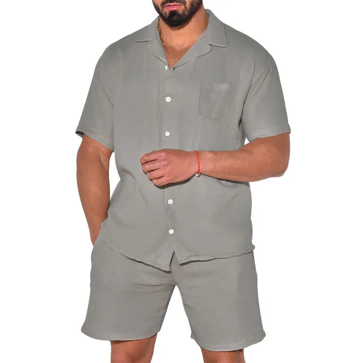 Man wearing light gray short-sleeve button-up shirt and matching shorts set