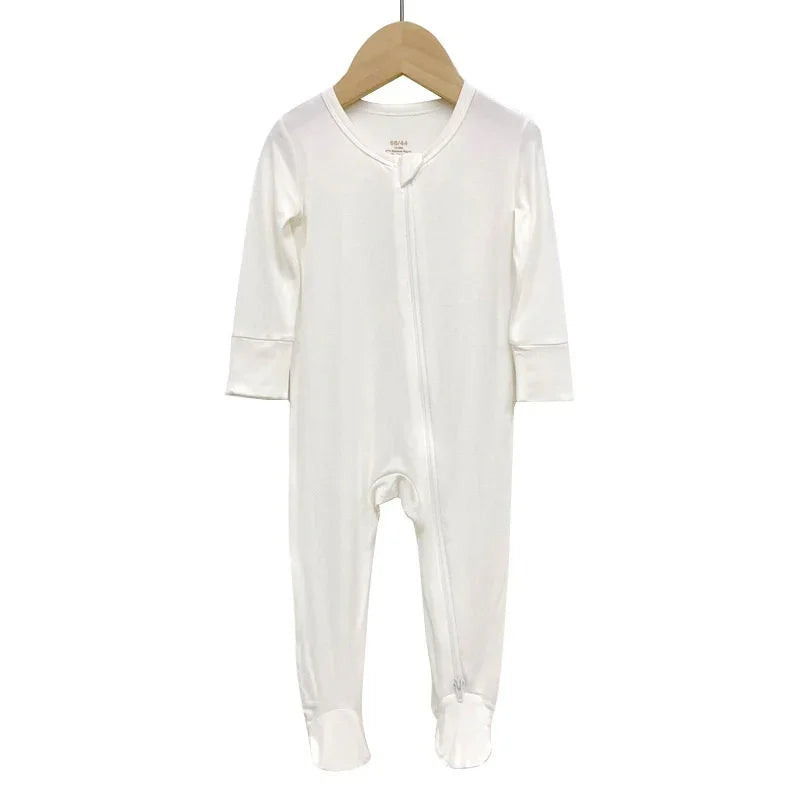 White long-sleeve baby onesie with footies hanging on wooden hanger