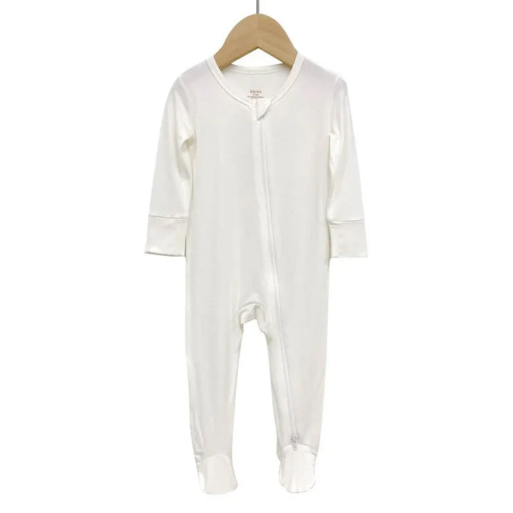 White long-sleeve baby onesie with footies hanging on wooden hanger