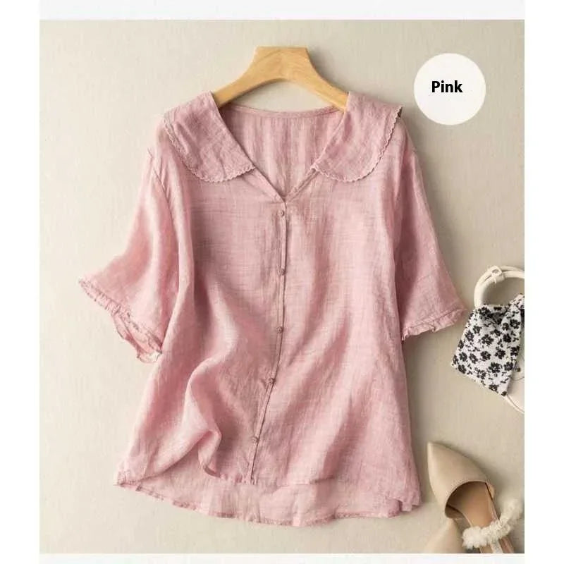 Light pink women's blouse with scalloped collar and button front on wooden hanger