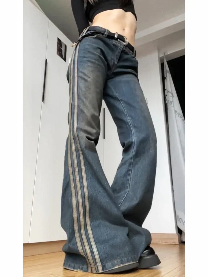 Wide-leg blue jeans with double side stripes worn with black belt and black crop top indoors