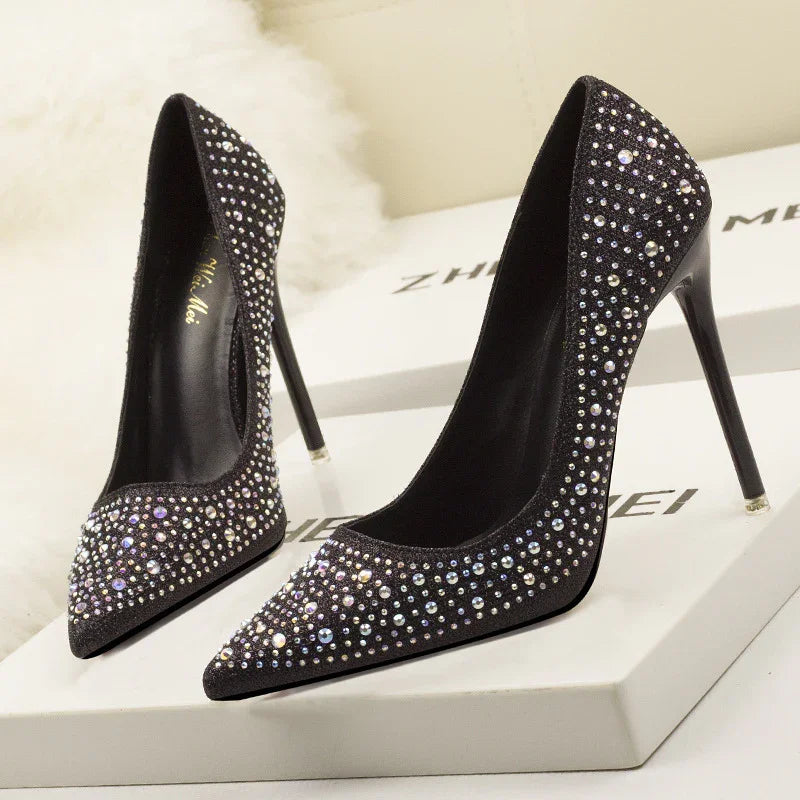 Elegant black high heel stiletto shoes adorned with sparkling rhinestones on display box