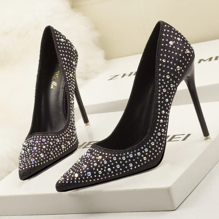 Elegant black high heel stiletto shoes adorned with sparkling rhinestones on display box