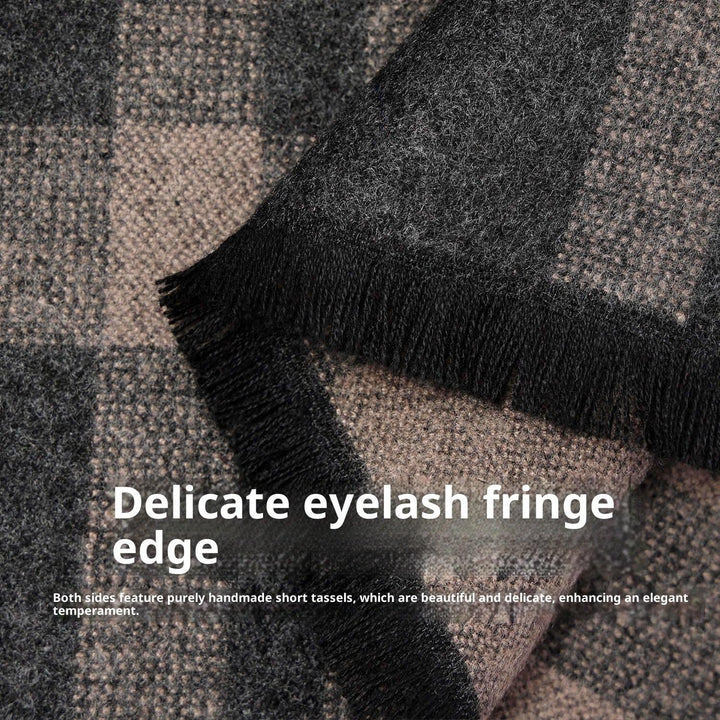 Close-up of a gray and black checkered wool scarf with delicate handmade fringe tassels