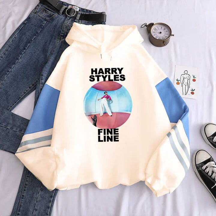 White hoodie with blue sleeves featuring Harry Styles Fine Line album cover, paired with jeans and sneakers