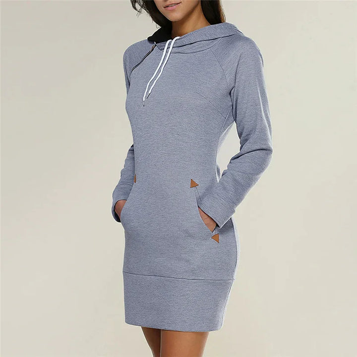Woman wearing a gray hooded sweater dress with front pockets and white drawstrings