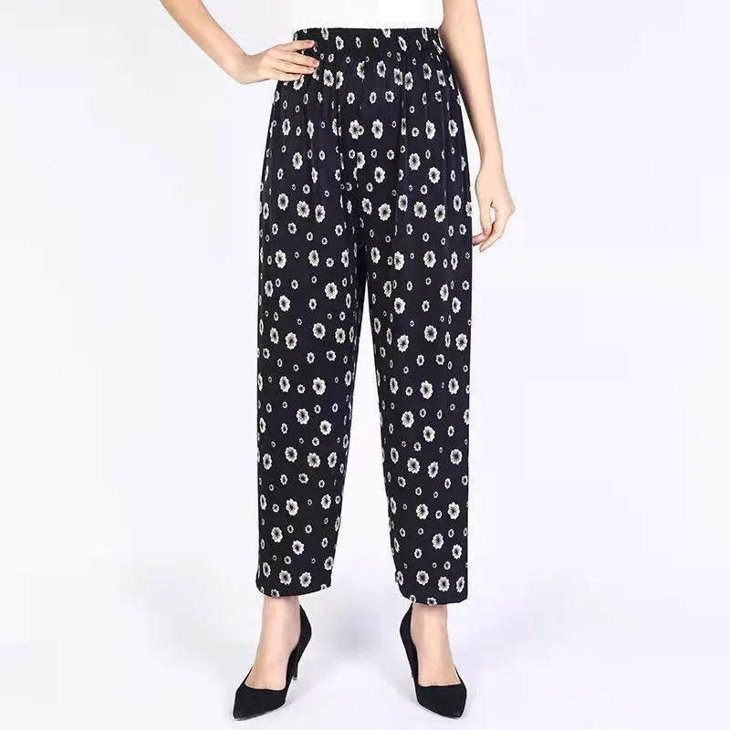 Black high-waisted women's pants with white floral print, paired with black heels