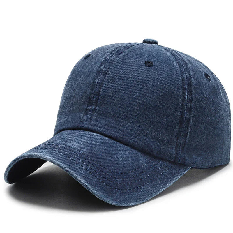 Navy blue washed cotton baseball cap with curved brim and stitched ventilation eyelets