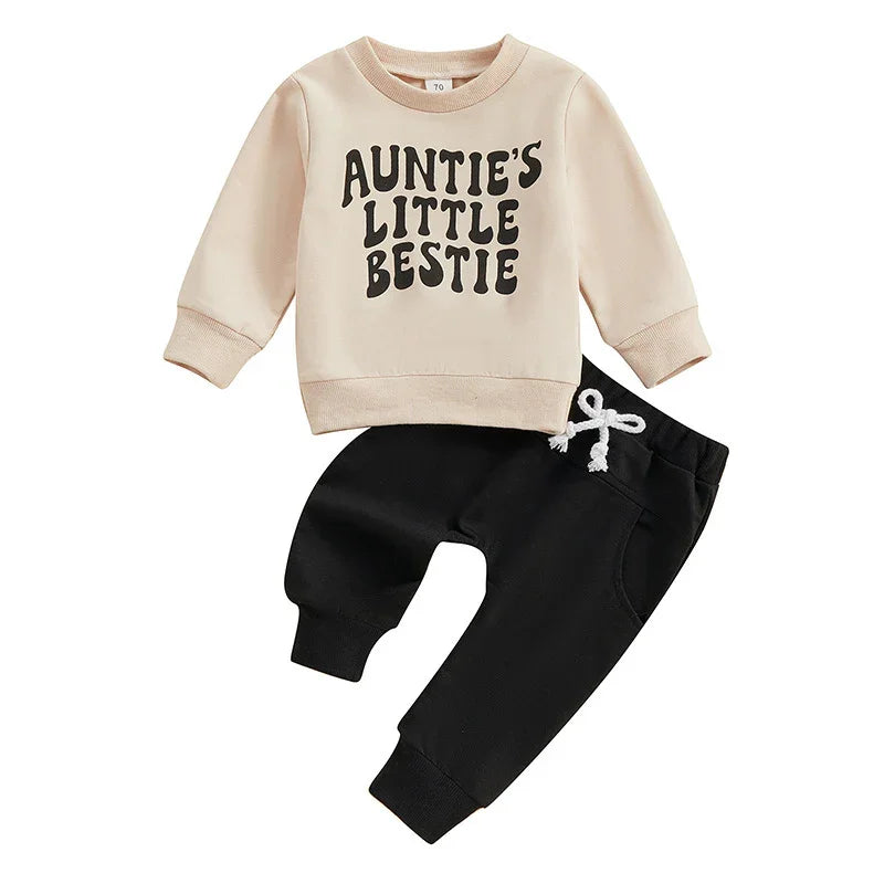 Beige toddler sweatshirt with 'Auntie's Little Bestie' text and black jogger pants with white drawstring