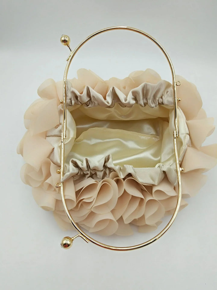 Top view of beige ruffled fabric handbag with gold metal frame and clasp