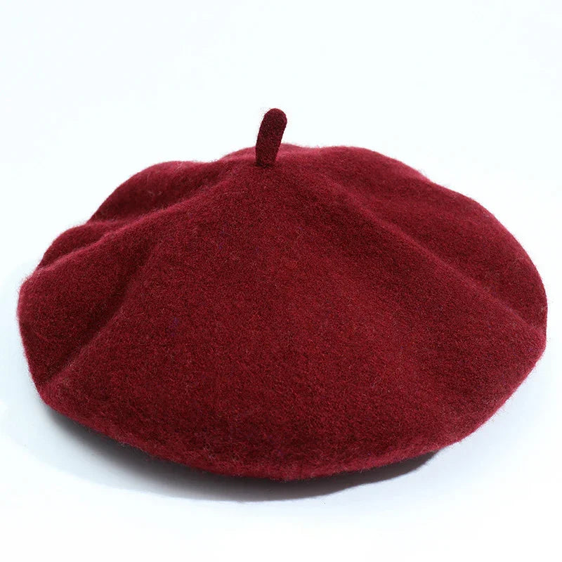 Classic deep red wool beret hat with top stem on white background