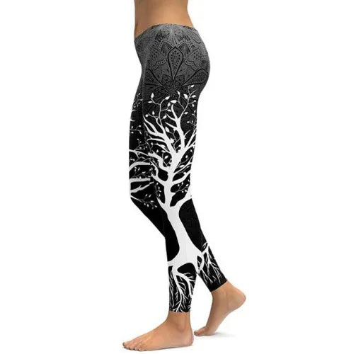 Black and white leggings with a tree design on legs worn by a person barefoot