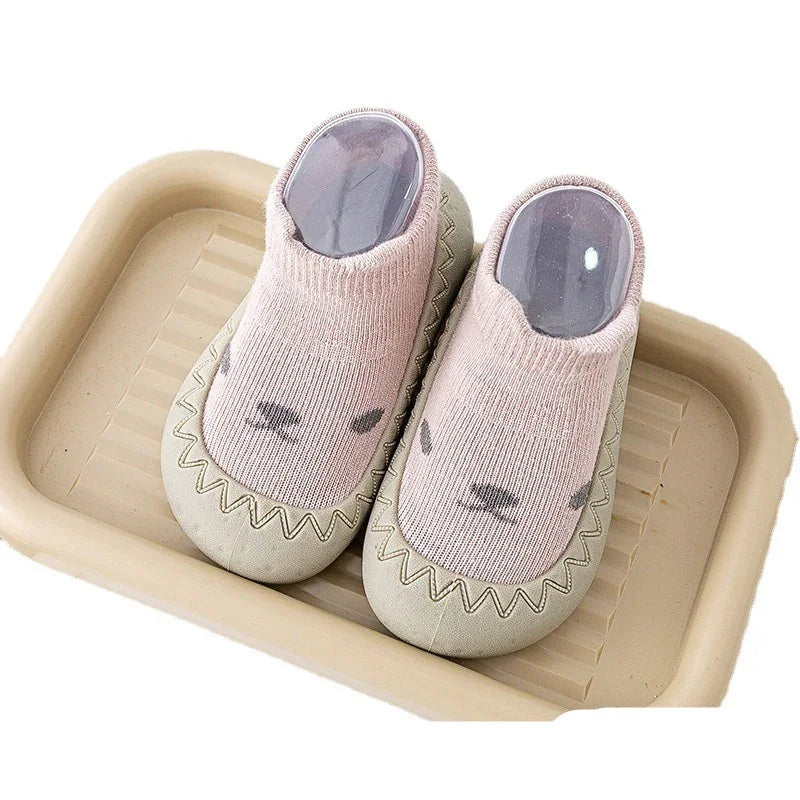 Pink baby soft sole shoes with animal face design on beige tray