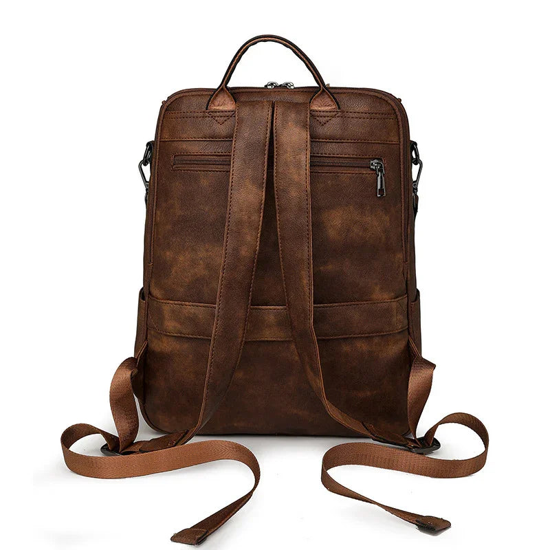 brown vintage leather backpack with adjustable shoulder straps and top handle on white background