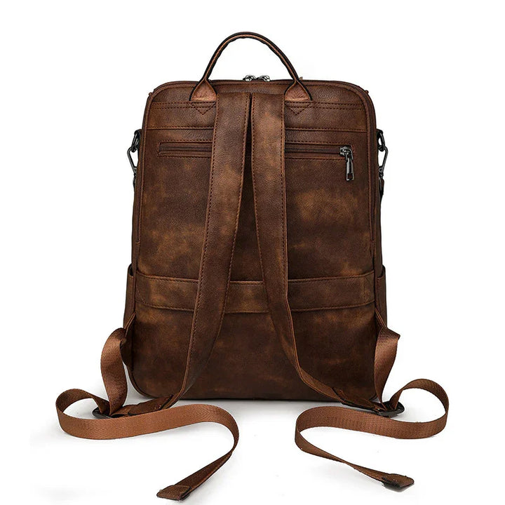 brown vintage leather backpack with adjustable shoulder straps and top handle on white background
