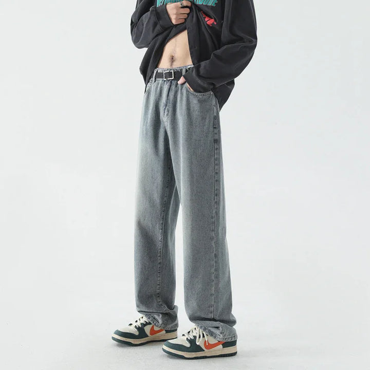 Casual outfit featuring loose-fit gray jeans, black belt, black sweatshirt, and white sneakers with orange swoosh