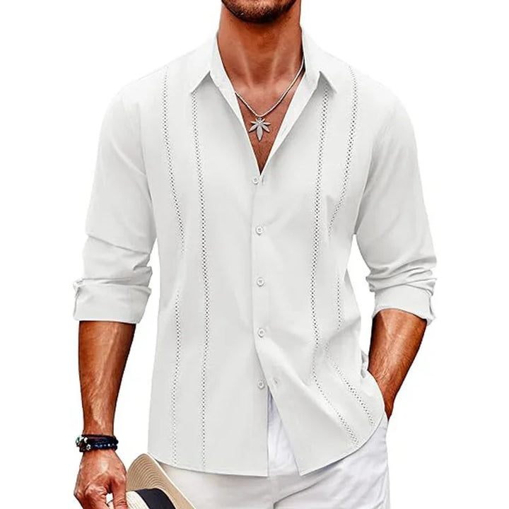 Man wearing white long-sleeve button-up shirt with vertical cutout designs, rolled sleeves, and necklace