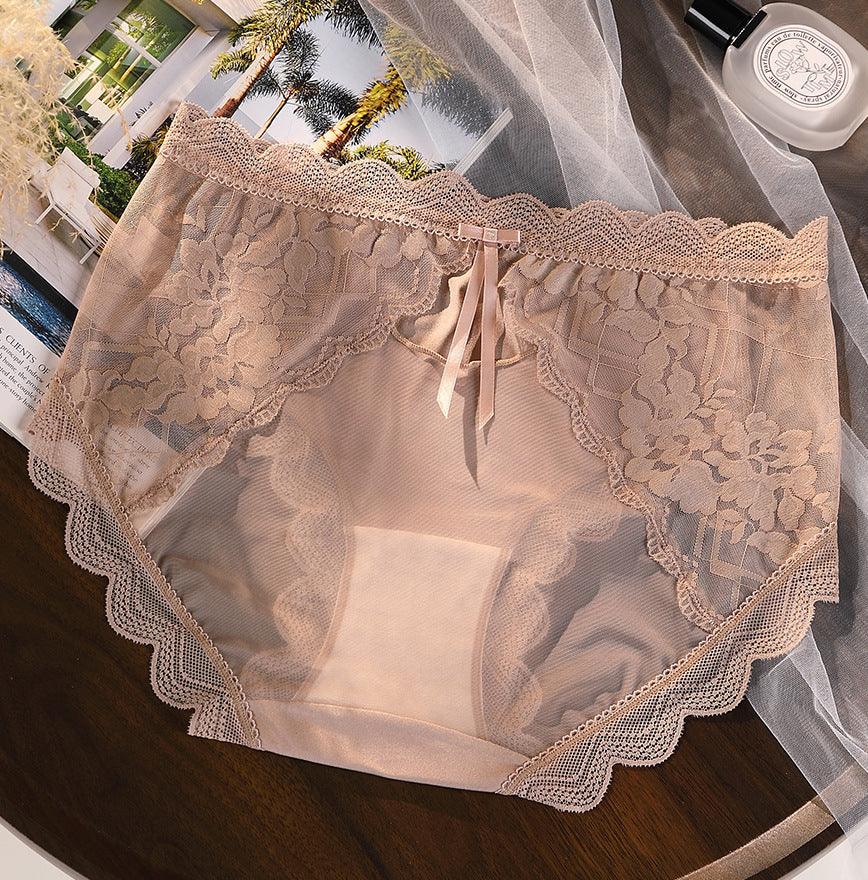 Beige lace women's underwear with floral patterns and scalloped edges on dark wooden surface