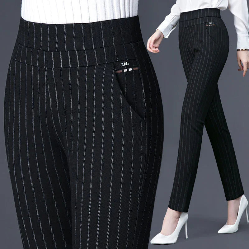Black pinstripe slim-fit women's trousers styled with white high heels and a white top