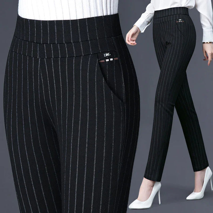 Black pinstripe slim-fit women's trousers styled with white high heels and a white top