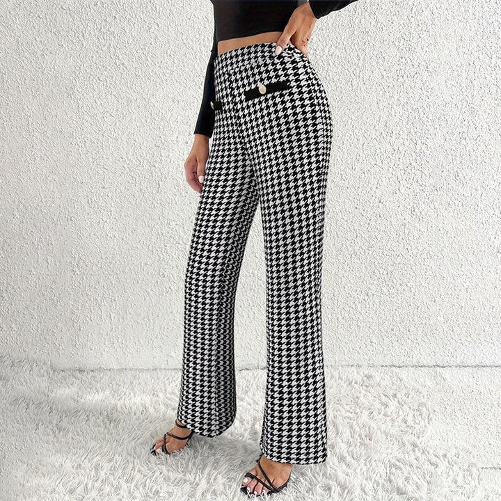 Woman wearing high-waisted black and white houndstooth pants with button detail, paired with black crop top and strappy heels