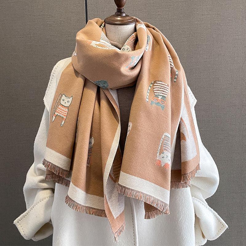 Beige scarf with cute cat patterns draped on a white coat on a mannequin
